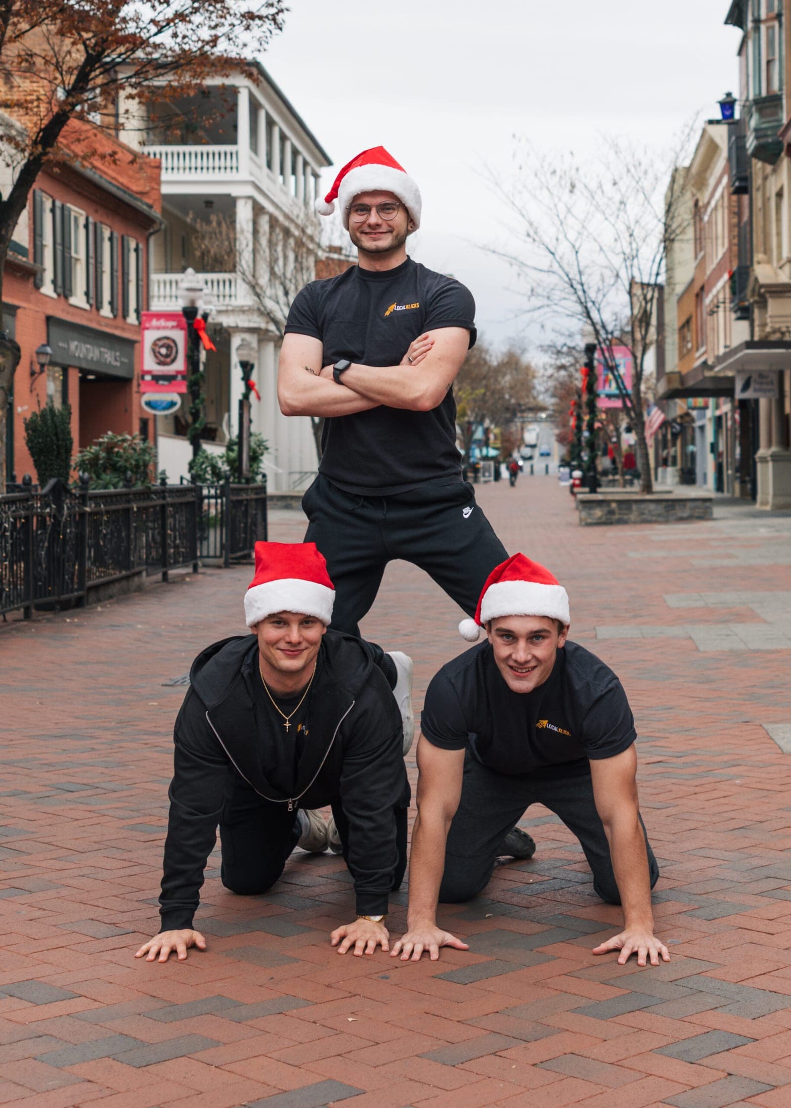 Sean Hodel and the Local Klicks team in Santa hats, stacked in a human pyramid on the Winchester walking mall